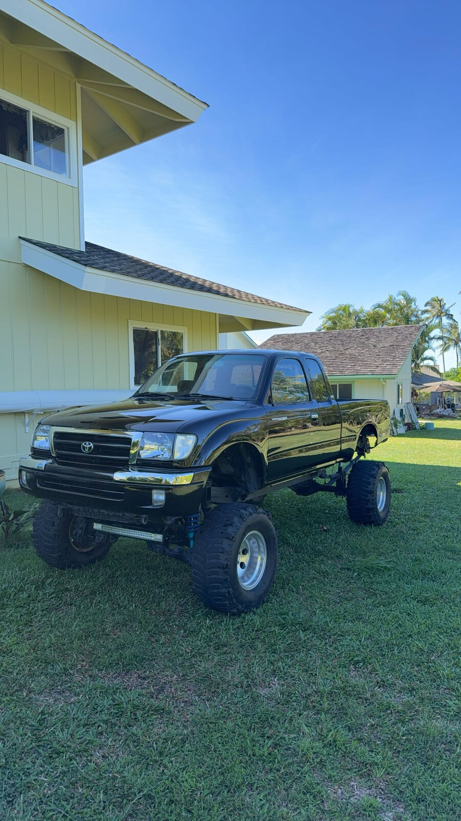 Lifted black Toyota pickup parked on grass