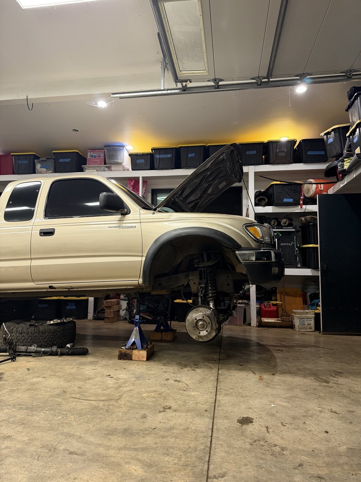 White Toyota Tacoma on jack stands inside a garage