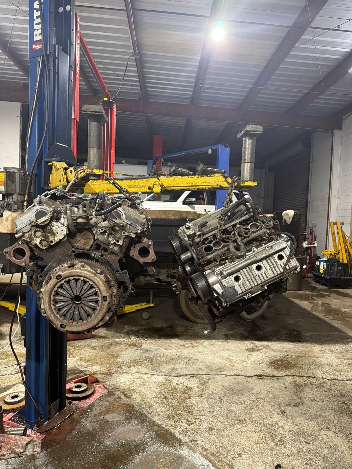 Engine and drivetrain assemblies inside an automotive workshop